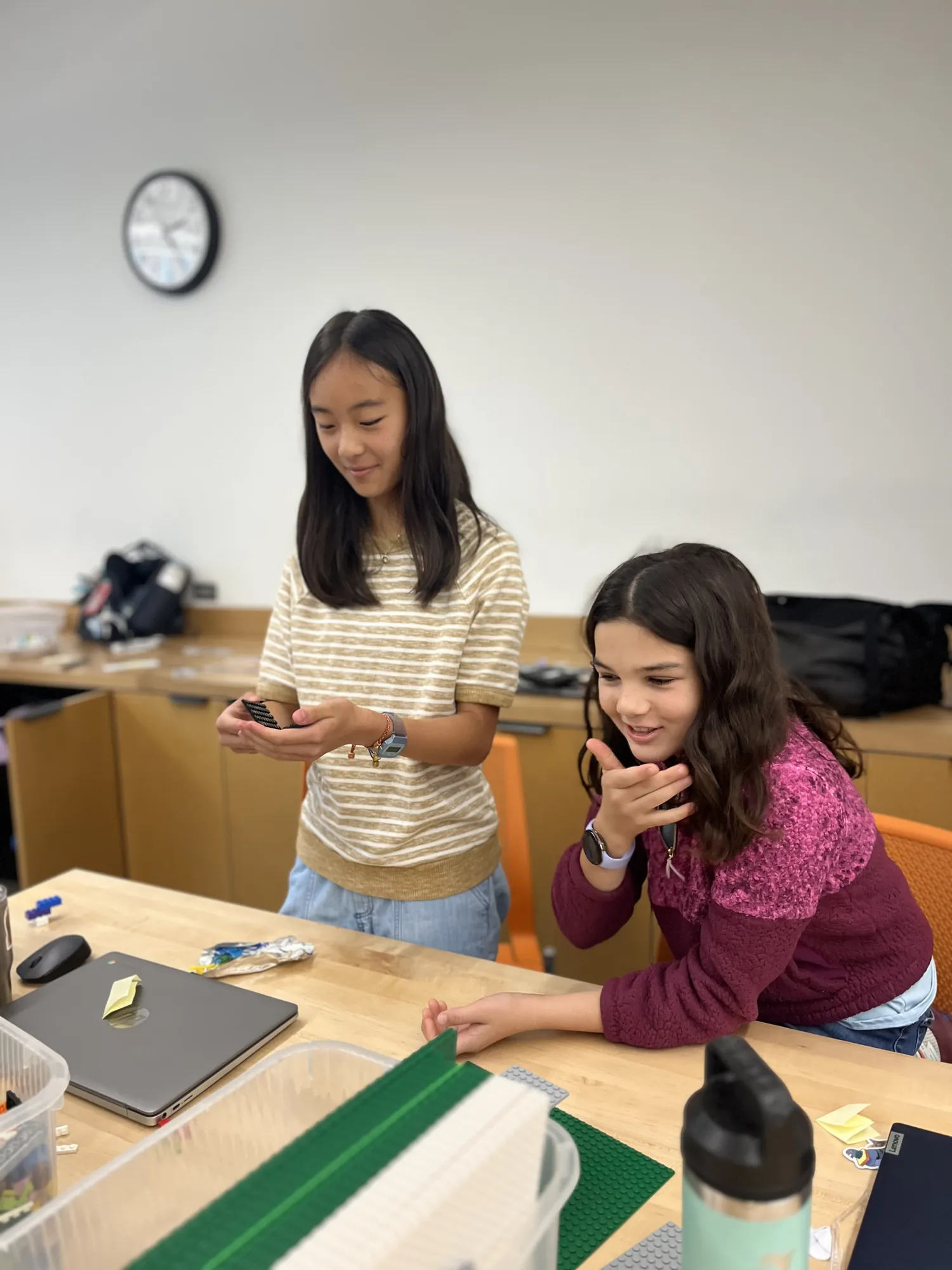 Two students laugh together at a table during a session