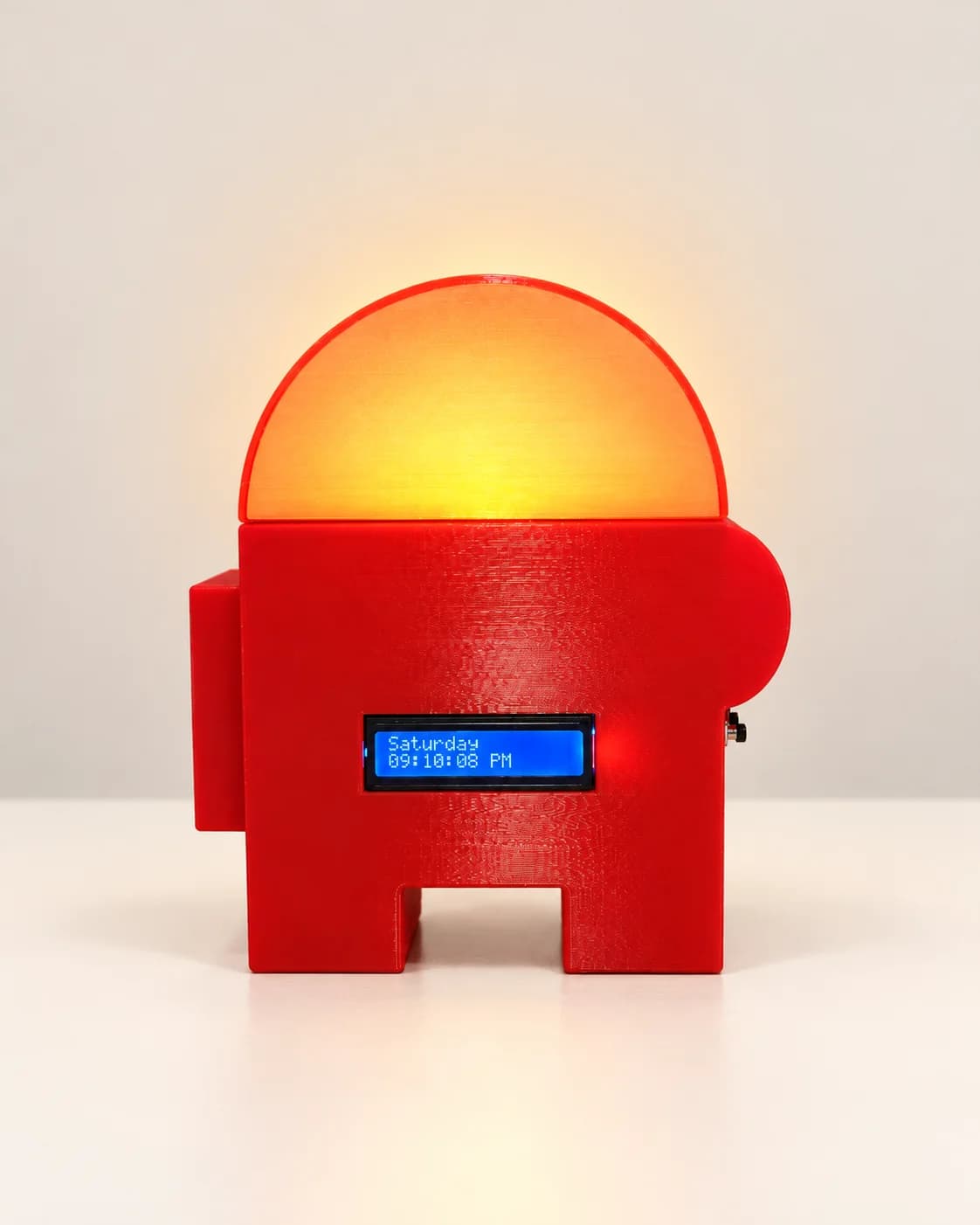 A red alarm clock shaped like a game character, its dome glowing warm yellow