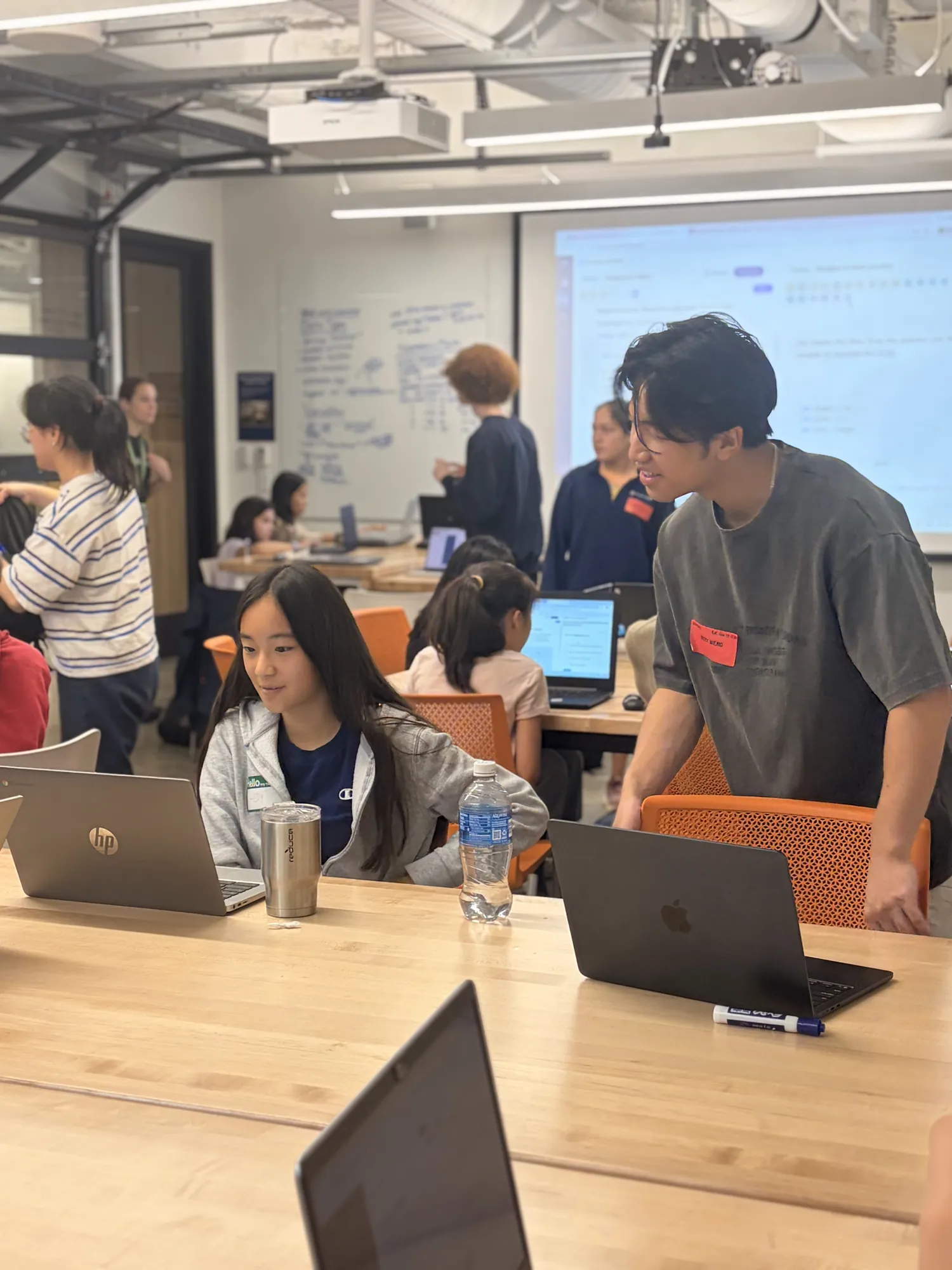 A university mentor checks in on a student's work during a session