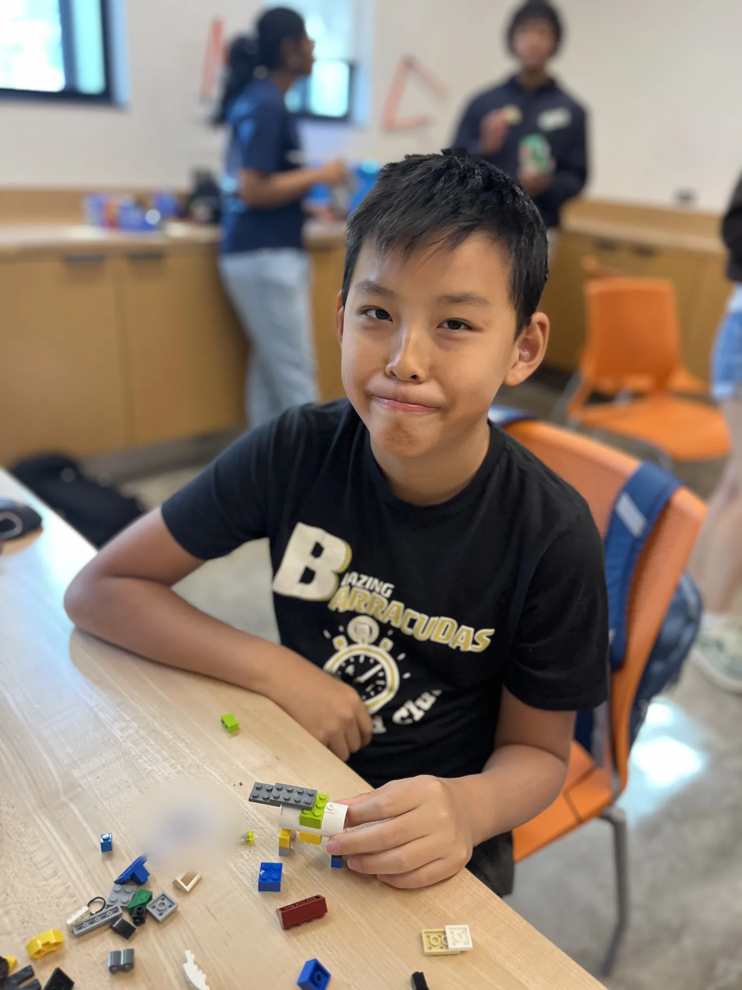 A student holds up the model he built